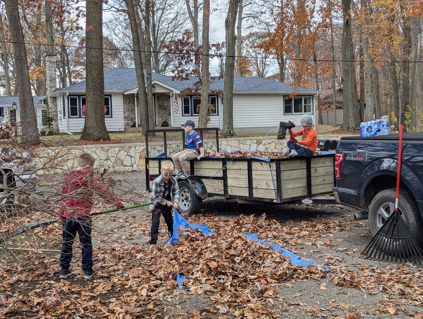 Eagles players loading raked leaves onto a trailer for a neighbor